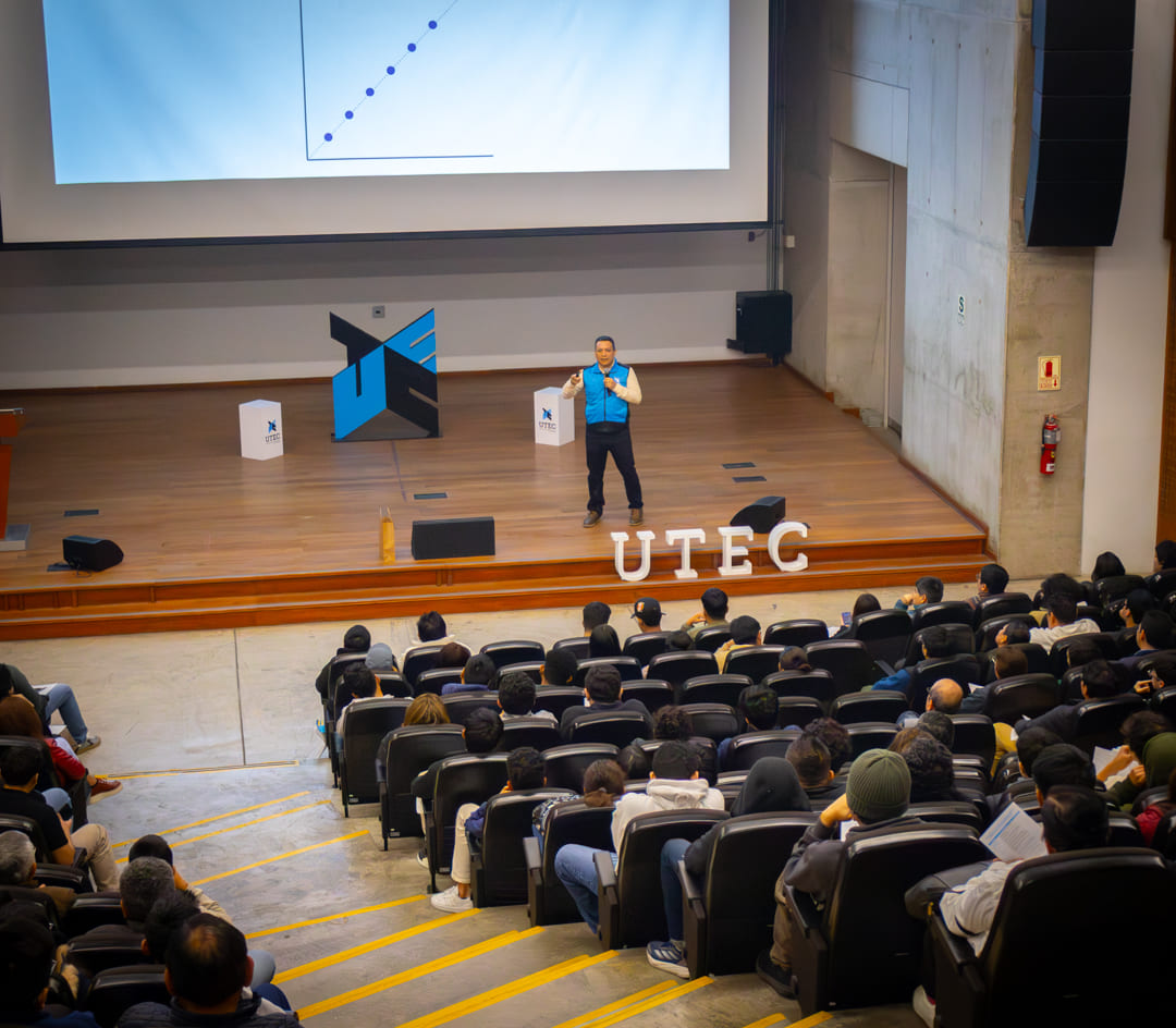 Vista panorámica de un auditorio lleno de estudiantes escuchando a un ponente en UTEC, destacando la infraestructura de la calidad educativa en Perú