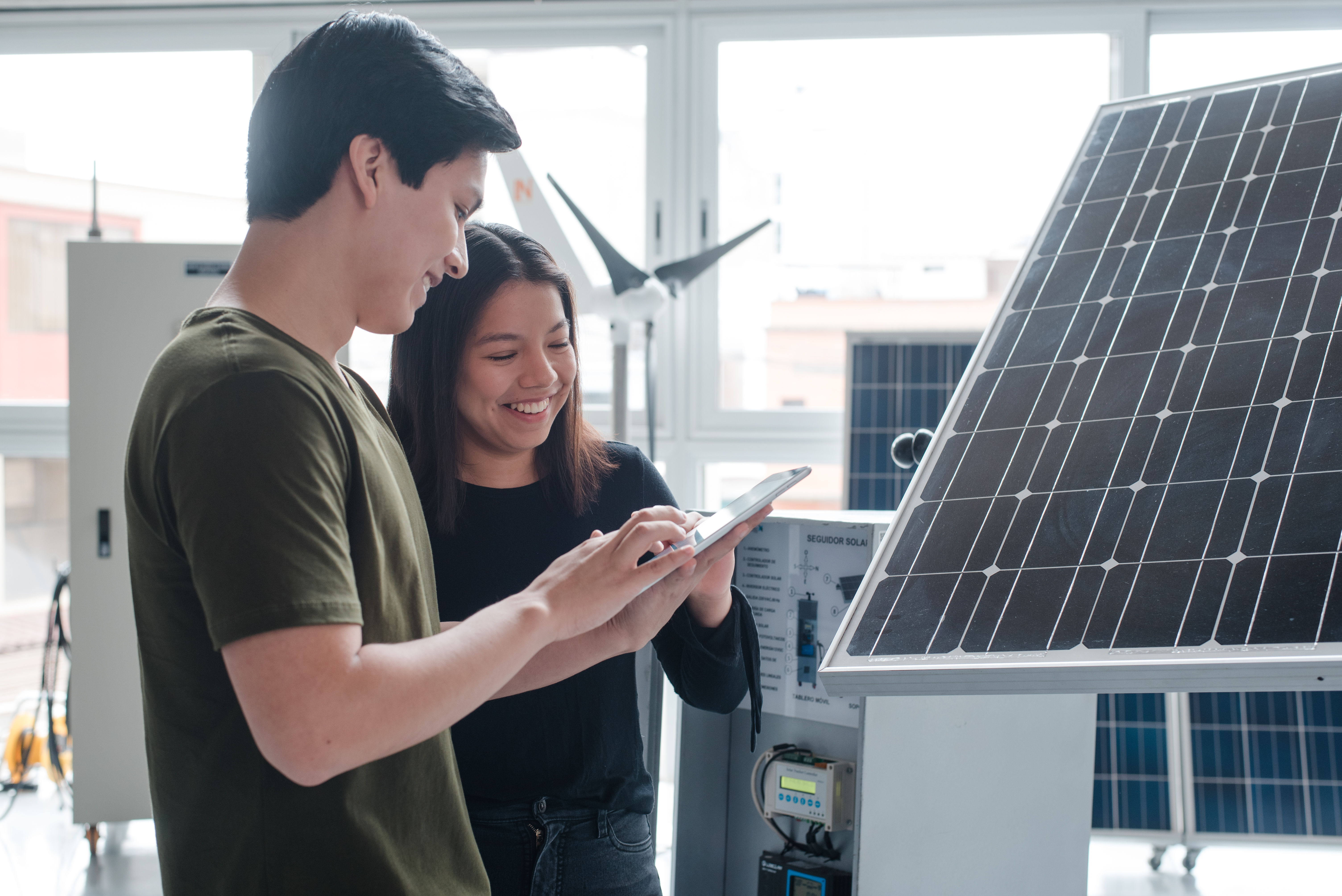  Profesionales analizando un panel solar, representando la ingeniería de energía como una de las carreras mejor pagadas en Perú