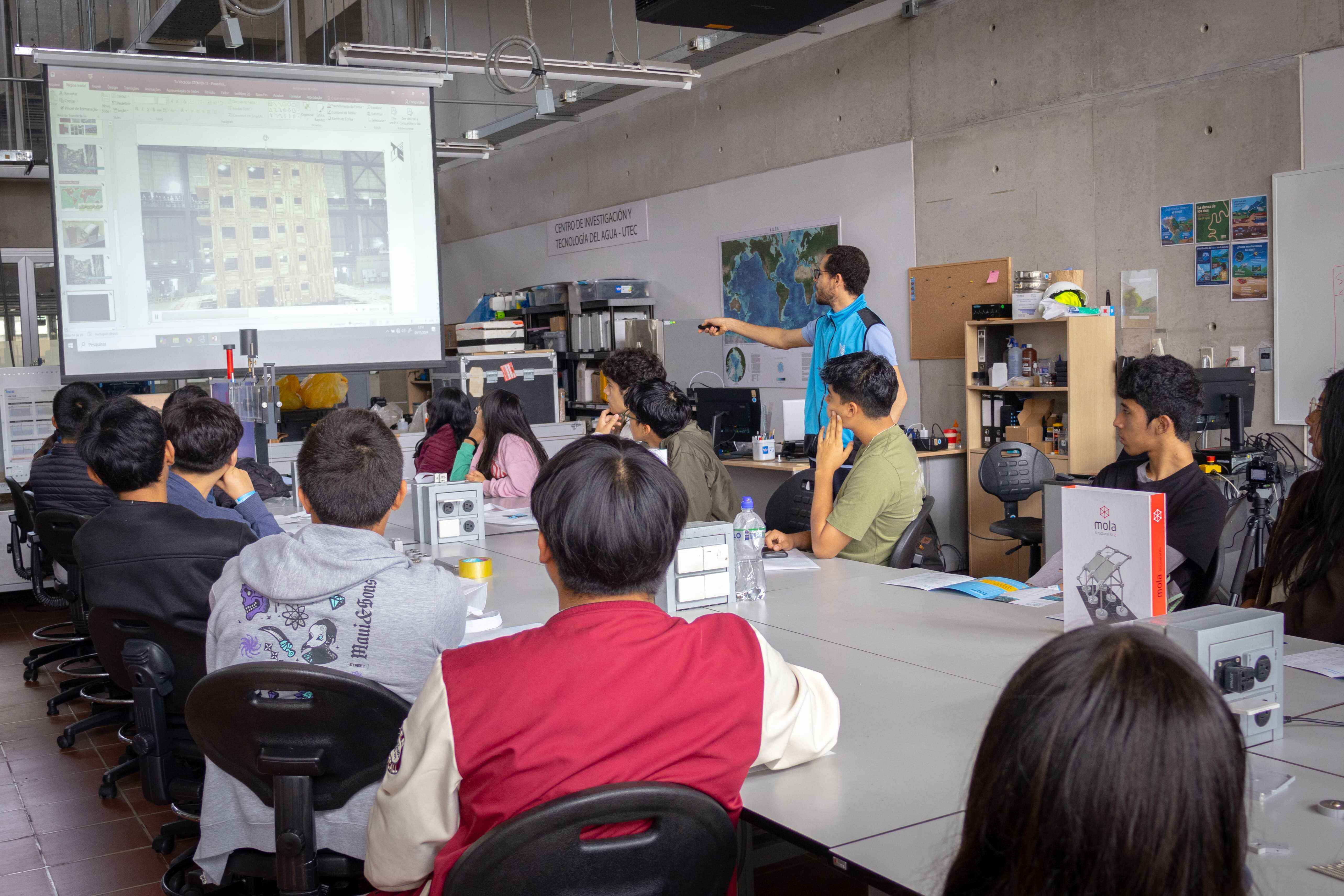 Estudiantes en un laboratorio tecnológico asistiendo a una presentación sobre carreras con inteligencia artificial y proyectos de ingeniería