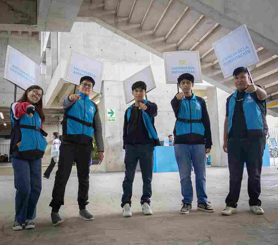 Grupo de jóvenes universitarios de carreras de ingeniería y ciencia de la computación posando con letreros, representando la calidad educativa en Perú